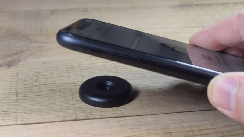 iphone held close to an industrial nfc disc tag